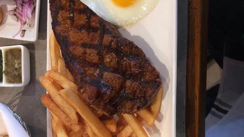 Bistec a Lo Pobre · Grilled New York steak served with fried plantains, French fries, fried egg and rice.