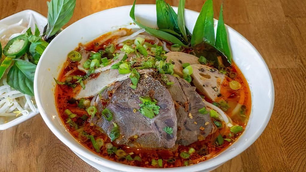 Spicy Hue · Favorite item. Thick rice noodles, spicy beef broth, sliced beef, peppered pork ham, and fresh herbs. Served spicy.