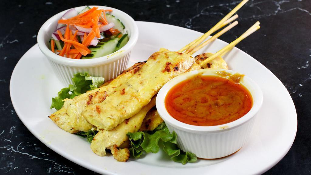 Chicken Satay · Grilled chicken on skewers, marinated with Thai spices and served with peanut sauce and cucumber salad.
