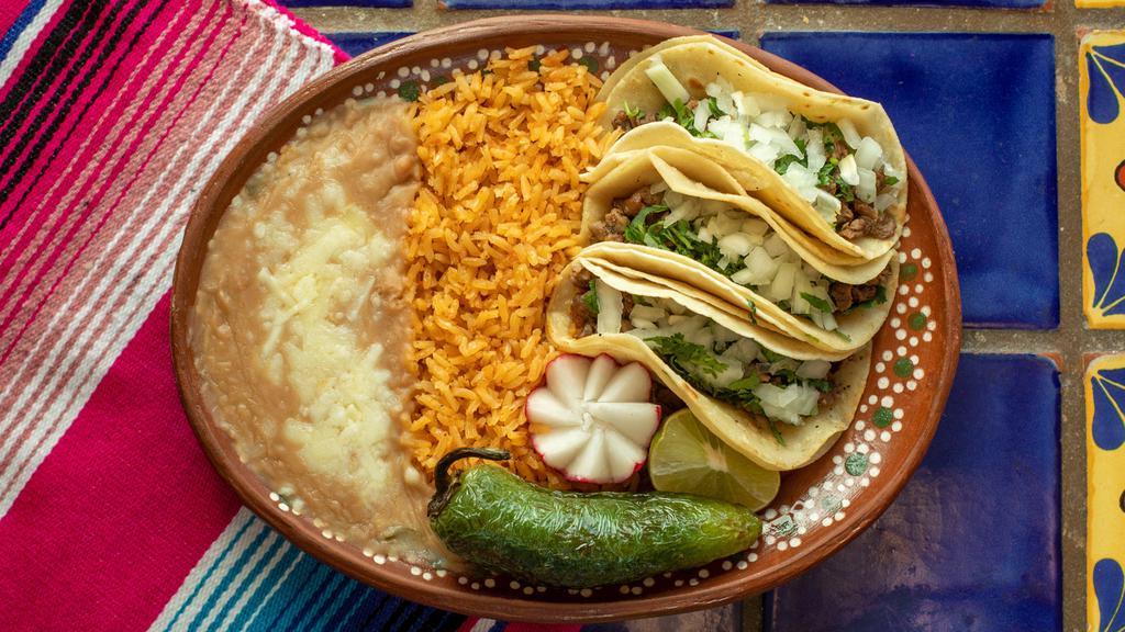 Taco Plate · 3 soft corn tortilla tacos, your choice of meat, onion cilantro, side of rice and beans.