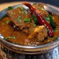 Goat Curry - 2 Pints (32 oz) · A succulent cut of Goat pieces cooke in the traditional Sout Indian style with rich curry sa...