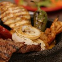 Molcajete Tradicional · Grilled carne arrachera, chicken breast, spicy shrimp, fire-roasted onion, chile burrito and...