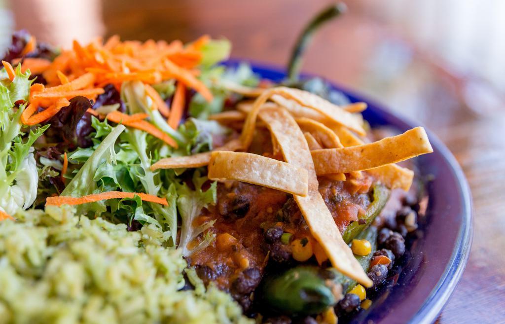 Vegan Stuffed Pasilla · Fire-roasted pasilla pepper stuffed with a black bean and corn medley, drizzled with salsa ranchera and topped with corn tortilla strips. Served with cilantro rice and a spring mix salad with pico de gallo on the side.
