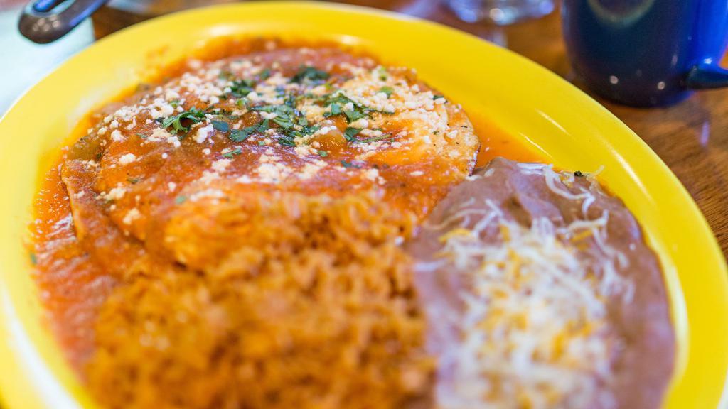 Huevos Rancheros · Three eggs over crispy corn tortillas topped with salsa ranchera, Queso Cotija, and cilantro. Served with beans and rice. (no tortillas on side.)