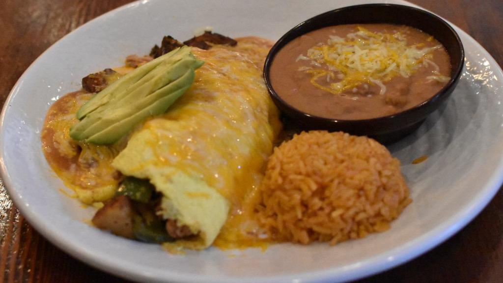 Guanajuato Omelet · Shredded chicken and home fries, topped with guajillo enchilada sauce, shredded cheese, and avocado slices. Served with beans, rice, and tortillas.