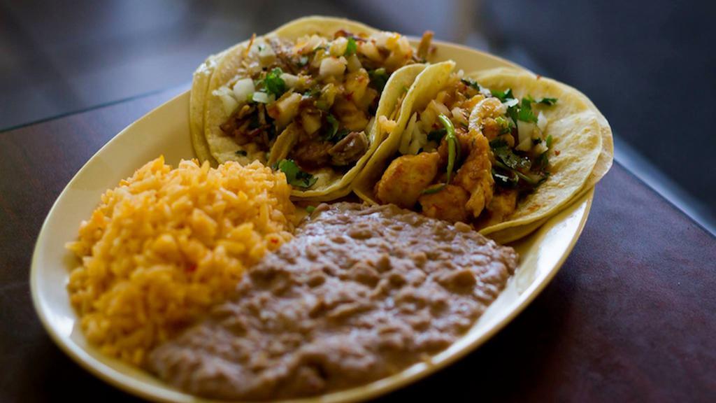 Taco Plate · 2 Tacos served with rice and beans.  Tacos are topped with onions, cilantro, and salsa. Your choice of meat and type of beans.