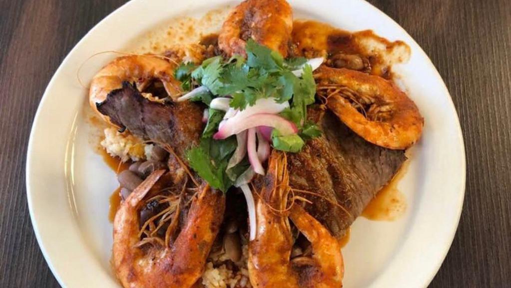 Tierra y Mar · Seared prawns, eight ounces grilled tasajo, guajillo pepper sauce, habanero relish, red rice, and pinto beans.