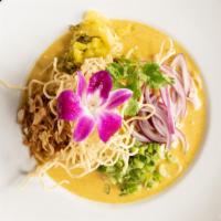 91. Kao Soy Soup · Egg noodles topped with yellow curry chicken, pickle green mustard, and red onions.