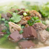 55. Tom Luad Moo · Pork blood pudding in clear broth with pork entrails and marinated ground pork.