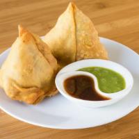 Vegetable Samosa (Vegan) · Deep fried triangular pastry stuffed with mildly spiced potatoes and green peas.