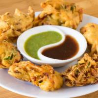 Vegetable Pakoda (Vegan) · Deep fried mixed vegetables spiced with chickpea batter.