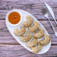 Chicken Momo · Steamed dumplings filled with minced chicken, chives, green onion & special spices.