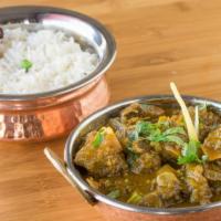 Goat Curry · Bone-in goat meat cooked with homemade herbs and spices in curry sauce. Served with rice.