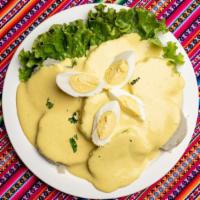 Papa A La Huancaina · Creamy sauce, made from fresh cheese, milk, Peruvian yellow pepper and garlic, served over l...