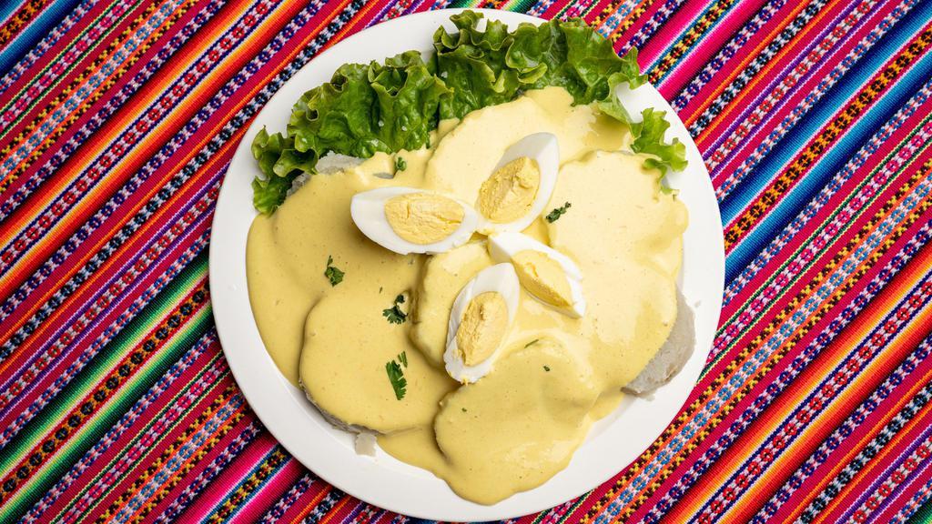 Papa A La Huancaina · Creamy sauce, made from fresh cheese, milk, Peruvian yellow pepper and garlic, served over lettuce and sliced boiled potatoes and a piece of hard-boiled egg.