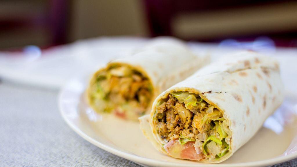24. Chicken Shawarma Wrap · Seasoned, slowly roasted chicken, shaved thinly, and served with lettuce, tomatoes, parsley, onions, and tahini wrapped in lavash bread.