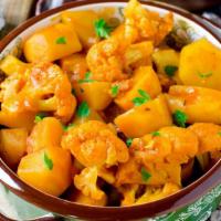 Aloo Gobhi · Famous vegetarian potato and cauliflower curry mixed with Indian spices, slowly cooked to pe...