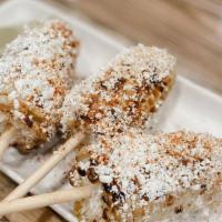 Elote · Grilled Mexican style street corn rolled in spices, topped with queso fresco, Cotija, and li...