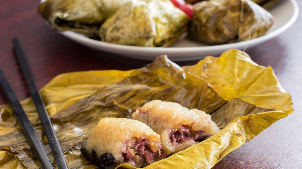 Sweet Sticky Rice with Banana · Sweet sticky rice filled with banana, black beans steamed in banana leaf.