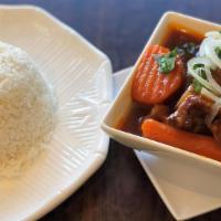 21. Wine Sauce Ox Tail with Rice · Oxtail and carrots mixed in homemade wine sauce topped with onions, cilantro, & scallion ser...