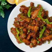 Sizzling Baby Corn Manchurian · Batter fried baby corn pieces tossed and coated in tangy garlic sauce.