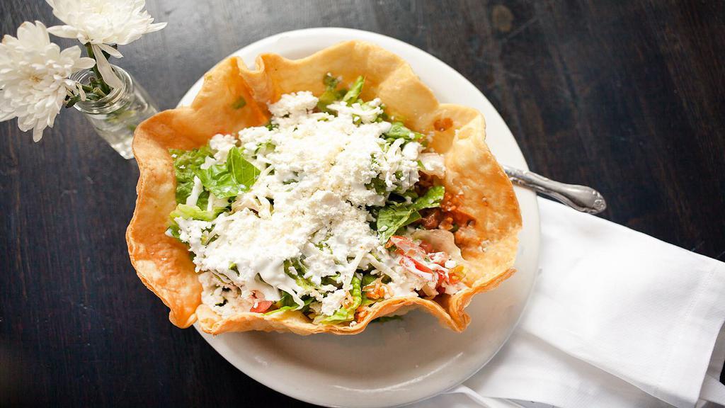 Taco Salad · crisp flour tortilla with whole beans, rice, shredded chicken, lettuce, salsa, crema, queso fresco, and guacamole