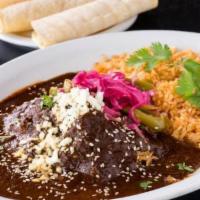 Mole Poblano · chicken in a dark mole sauce, pickled onions, jalapeños, ajonjoli, served with rice and tort...