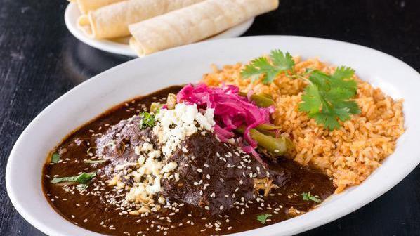Mole Poblano · chicken in a dark mole sauce, pickled onions, jalapeños, ajonjoli, served with rice and tortillas