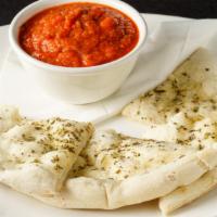 Fagioli All’uccelletto · Tuscan white beans in a light tomatoes sauce with a sage infusion served with flatbread.