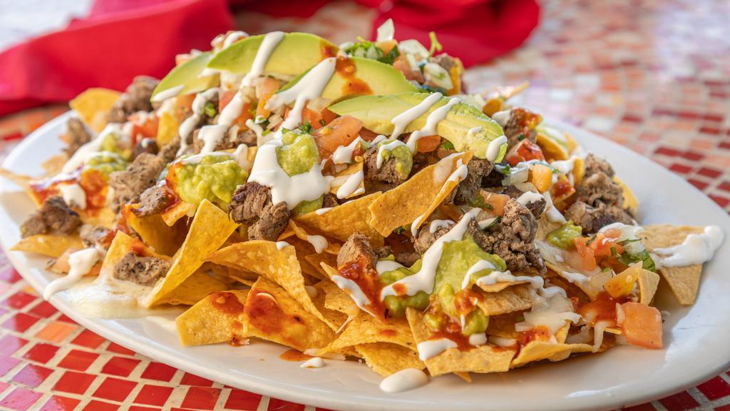 Reg Nachos No Meat · A mountain of chips covered with cheese, guacamole, sour cream and salsa fresca.