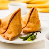Samosa · Two pieces crispy golden turnover filled with spice potatoes and green peas with a side of m...