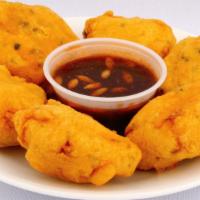 Paneer Pakora · Crispy golden cheese fritters served with a side of mint and tamarind chutney.