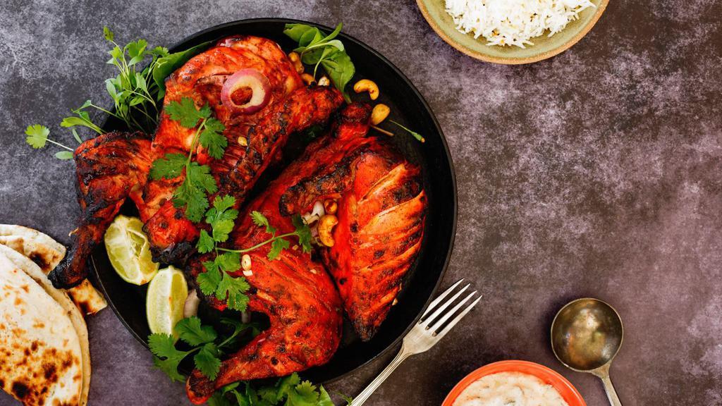 Chicken Tandoori (Full) · Tender bone-in chicken marinated with yogurt, chopped garlic, and fresh ground spices then baked in a traditional tandoori oven.