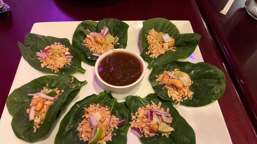 Miang Kum · Vegetarian. Wrapped in spinach leaf each bite contains roasted sweet coconut, sliced lime, red onion, ginger and cashew nuts served with sweet ginger sauce. (Vegetarian).