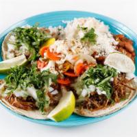 Slow Braised Berkshire Pork Carnitas Taco · Salsa verde, white onion, and cilantro. Includes three tacos, rice, and beans.