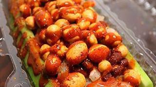 Pepino Split · A cucumber cut in 1/2 filled with tamarind candies, Japanese peanuts, chamoy, valentina and ...