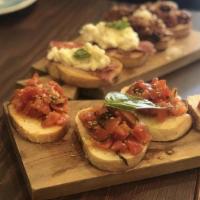 Bruschetta · Toasted housemade bread served with choice of : seasonal tomatoes with basil  or Fresh burra...