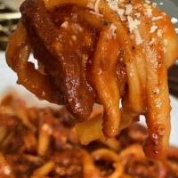 Amatriciana · Housemate bucatini pasta served with Guanciale, onions, mild spicy tomato sauce & Pecorino R...