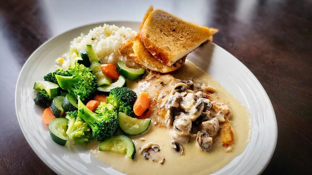 Pollo con Crema de Tequila · Chicken breast in a creamy tequila sauce, served with rice, vegetables and garlic bread.