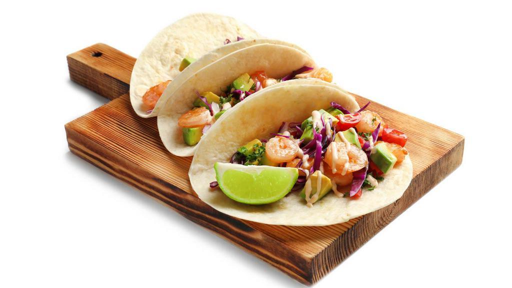 Baja-Style Shrimp Tacos · Two soft corn tortilla tacos stuffed with grilled shrimp and crisp cabbage. Topped with our house baja sauce, avocado, and fresh Jack and Cheddar cheeses.