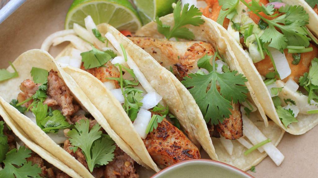 Baja Grilled Fish Tacos · Two soft corn tortilla tacos filled with grilled fish and crisp cabbage. Topped with our special baja sauce, fresh avocado, and Jack and Cheddar cheeses.