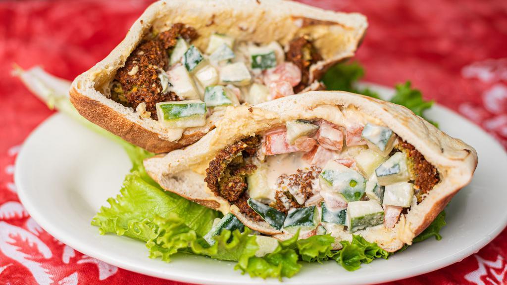 Falafel Deluxe Sandwich · Falafel in a pita, with hummus, tahini salad, and shatta spicy sauce.