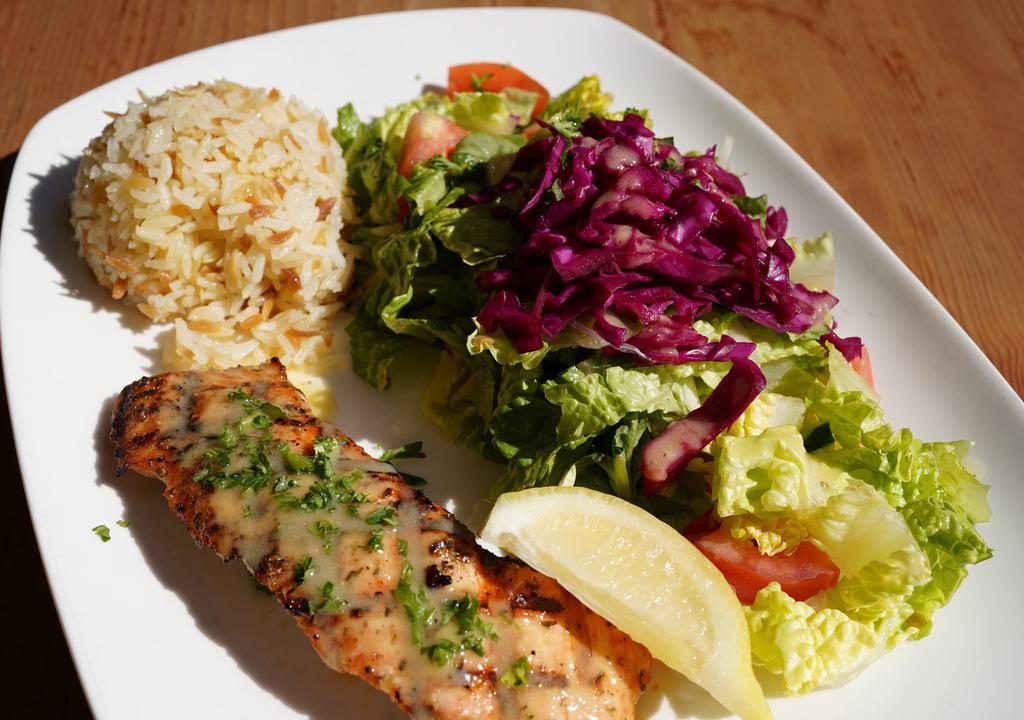 Grilled Salmon · served with rice & salad. Marinated with extra virgin olive oil, lemon, and fresh oregano.