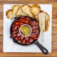 DAS SAUSAGE SAMPLER · sliced assorted beef and pork sausages on a bed of sauerkraut served with warm bread and who...