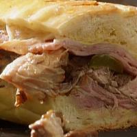 CUBAN PORK SANDWICH · pulled chipotle pork topped with ham, jack cheese, grilled onions and dijon mustard on ciaba...