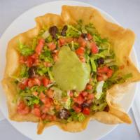 Taco Salad · Tortilla shell stuffed with choice of meat, rice, lettuce, cheese, diced tomatoes, sour crea...