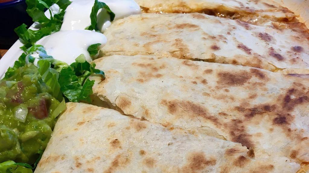 Chicken or Beef Quesadilla · Red enchilada sauce. All quesadillas are made with a 14” flour tortilla filled with melted cheese. Topped with sour cream and guacamole.