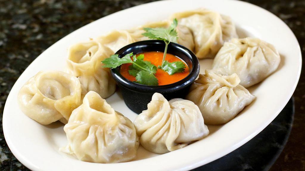 Veg Momo (7 Pieces) · Steamed dumplings filled with minced cabbage, spinach, mushroom, cashew nuts, cheese, onion, and cilantro. Served with tomato chutney.