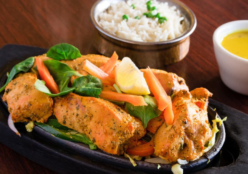 Chicken Tandoori Tikka · Boneless Chicken Breast first marinated in yogurt and spices, broiled in the tandoor oven. Served sizzling with sauteed veggies