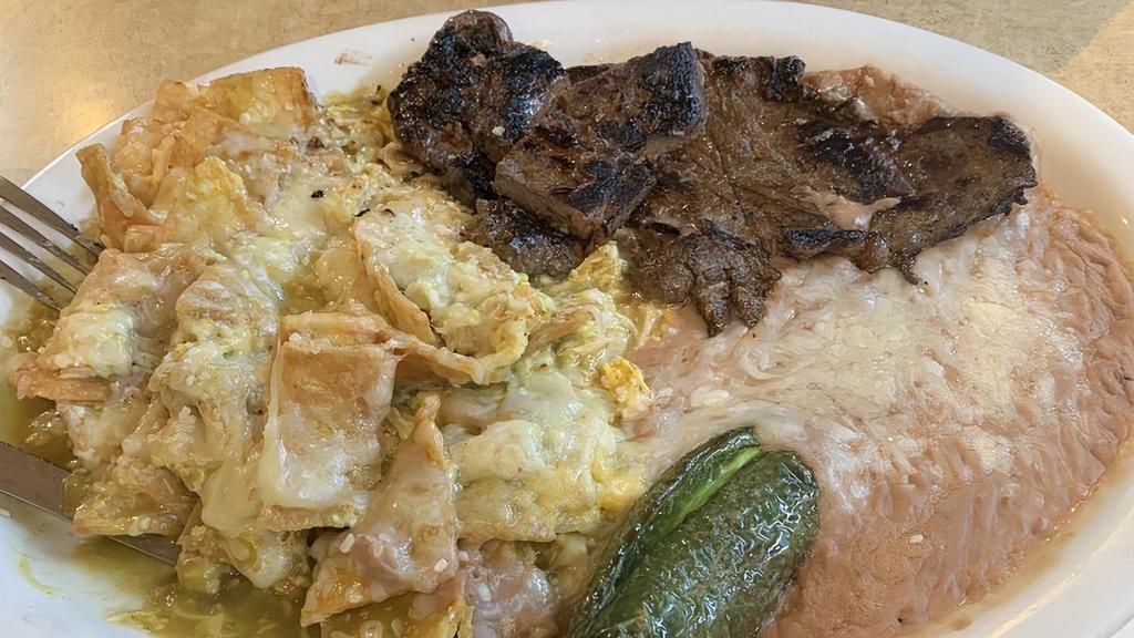 Chilaquiles con Carne / Chilaquiles with Beef · Picante. Chilaquiles en salsa roja o verde con bistec de solomillo (sin tortillas), (sin arroz). / Spiivy. Red or green sauce chilaquiles with sirloin steak (no tortillas), (no rice).